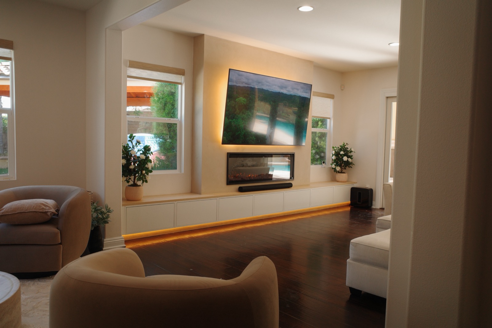 Media wall with floating credenza and linear fireplace, pool beyond